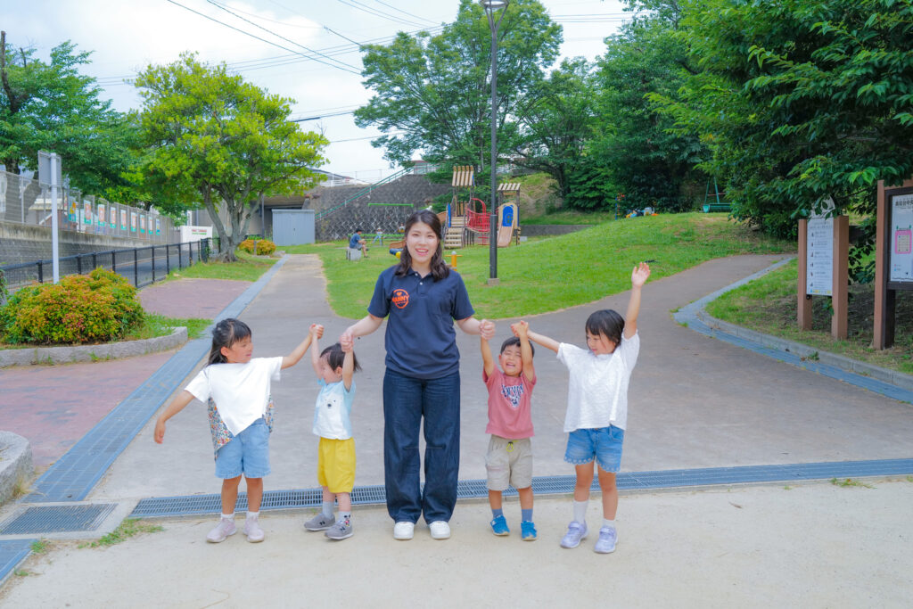 公園で子どもたちと手をつないで遊ぶNANNYのシッター